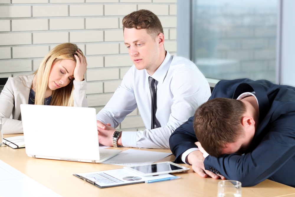 Boring work. Young business people looking bored while sitting t